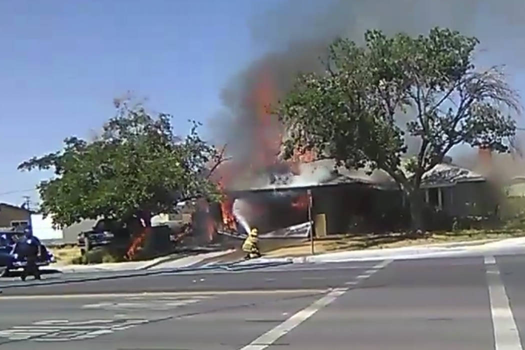 En una imagen tomada de un video, un bombero trabaja para extinguir un incendio en una casa el ...