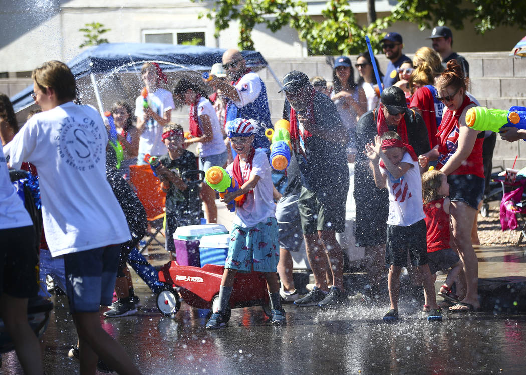 Los espectadores del desfile participan en peleas de agua durante el desfile en la celebración ...