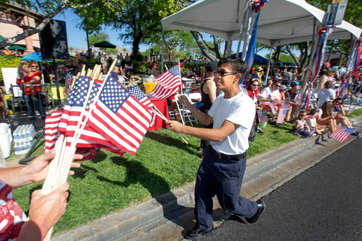 Angel Lemurs, de 16 años, reparte banderas estadounidenses durante el 25º desfile patriótico ...