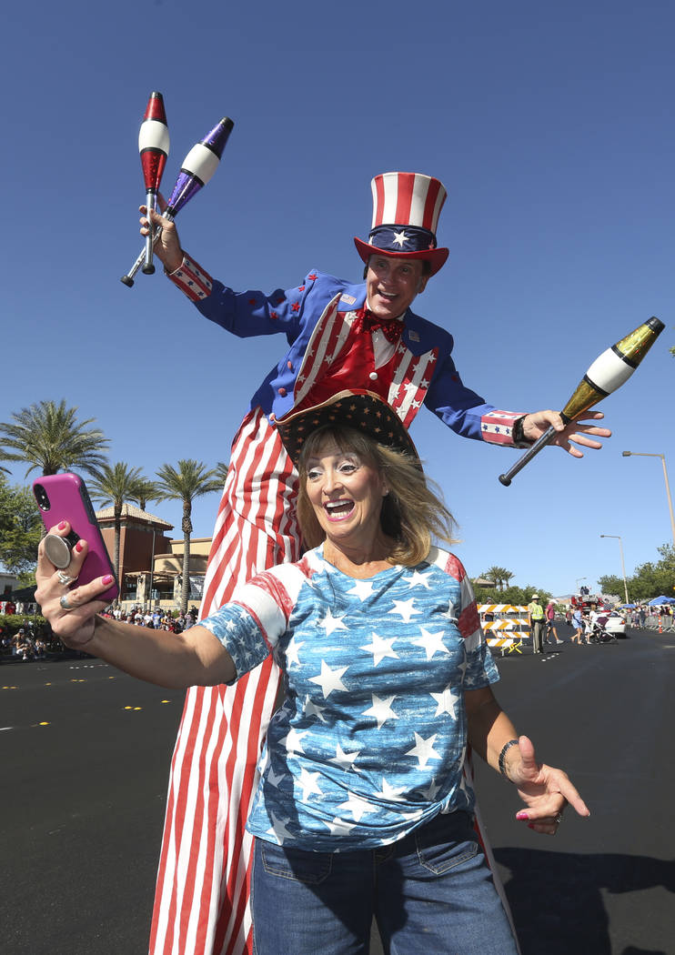 Kathy Koch toma una foto con un hombre vestido como el Tío Sam durante el 25º desfile patrió ...