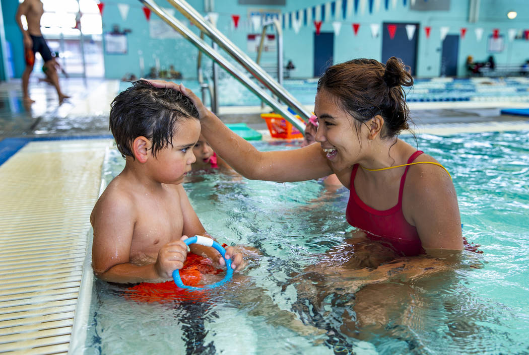 La instructora de natación Shanneal Ocular, habla con su estudiante Louis Borado, de 3 años, ...