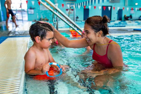 La instructora de natación Shanneal Ocular, habla con su estudiante Louis Borado, de 3 años, ...