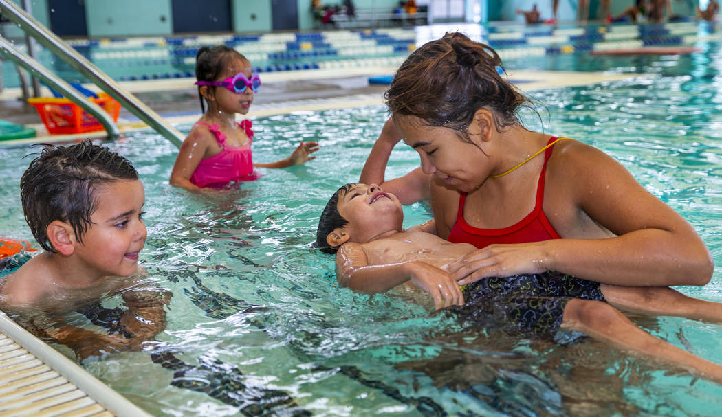 La instructora de natación Shanneal Ocular, derecha, ayuda a su estudiante Stefan Flores, de 4 ...