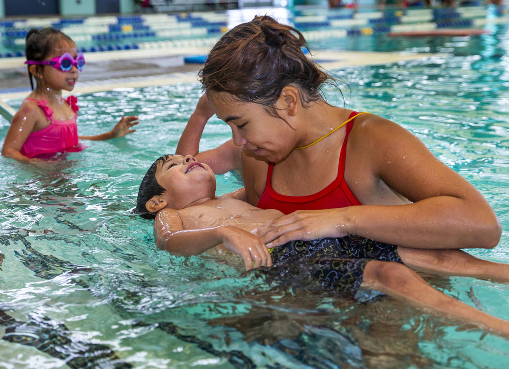 La instructora de natación Shanneal Ocular, derecha, ayuda a su estudiante Stefan Flores, de 4 ...