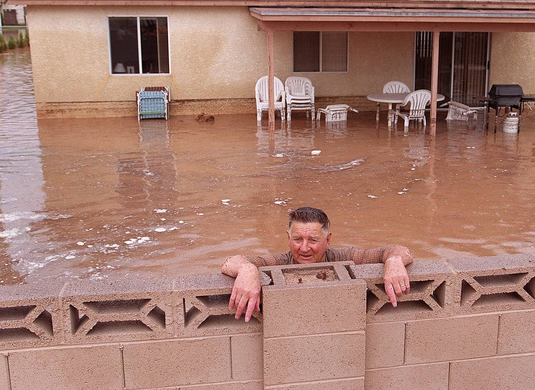 Un hombre se para en el patio trasero de su casa inundada durante la inundación de 1999. (Las ...