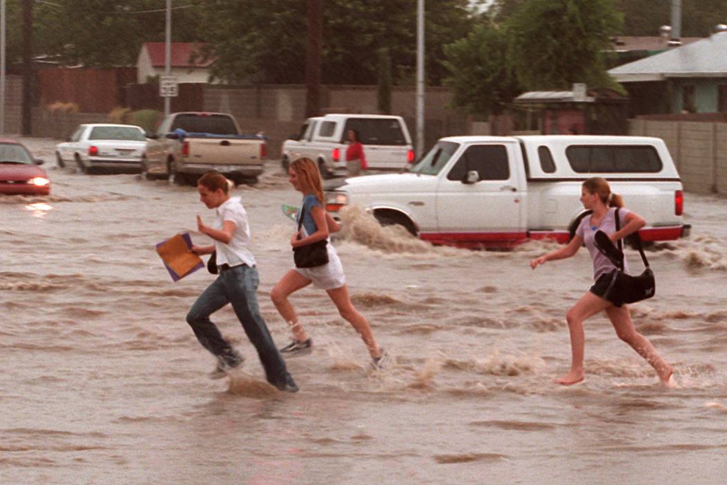 Niños cruzan una calle inundada cerca de Washington y Pecos. (Las Vegas Review-Journal)