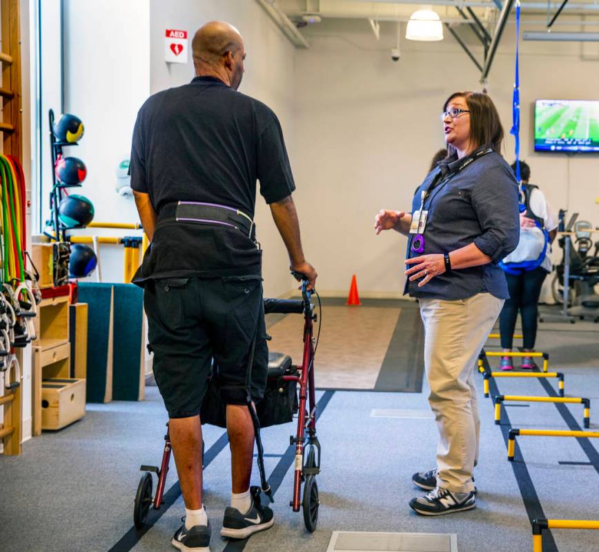 Una paciente consulta a la fisioterapeuta Christine Ross en un ejercicio de caminata en el depa ...