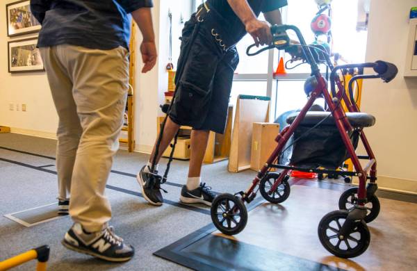 La fisioterapeuta Christine Ross trabaja con una paciente en un ejercicio de caminata en el dep ...