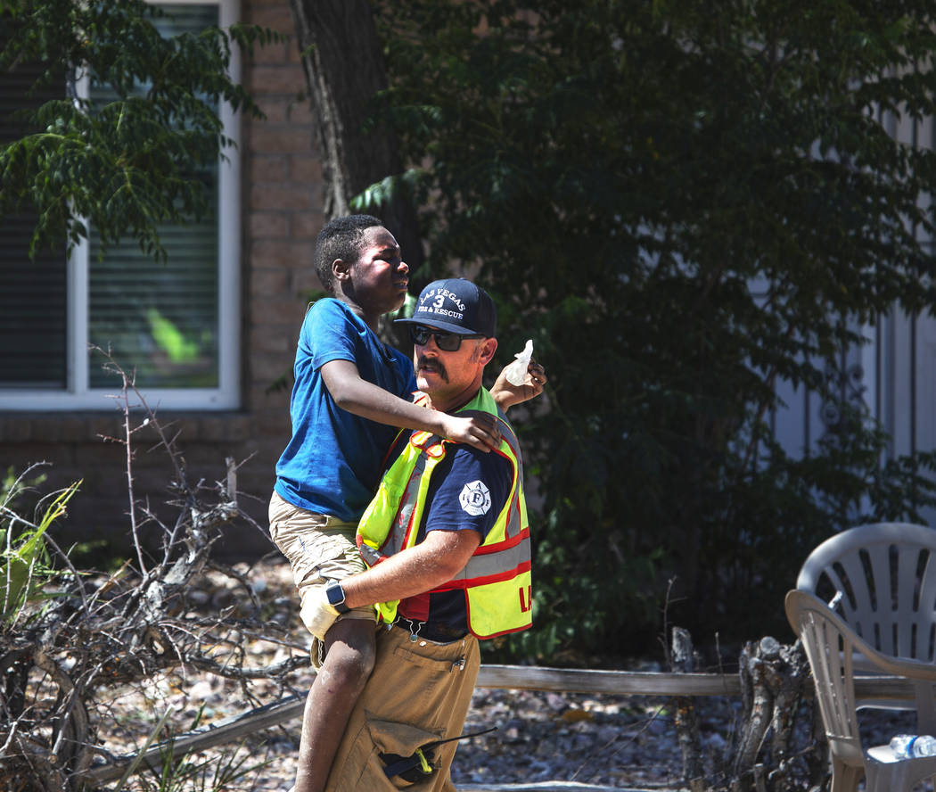 Un bombero carga a uno de los niños heridos en un accidente en West Washington Avenue cerca de ...