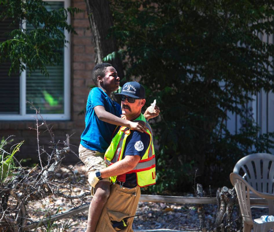 Un bombero carga a uno de los niños heridos en un accidente en West Washington Avenue cerca de ...