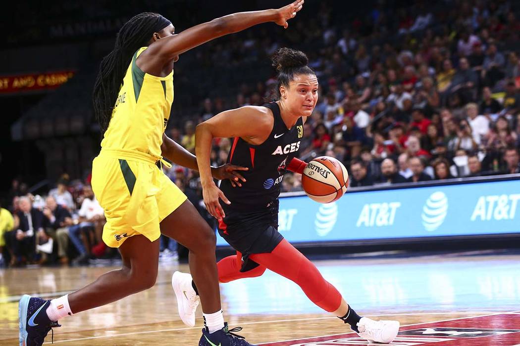 Kayla McBride, de Las Vegas Aces, a la derecha, conduce hacia la canasta pasando a Crystal Lang ...