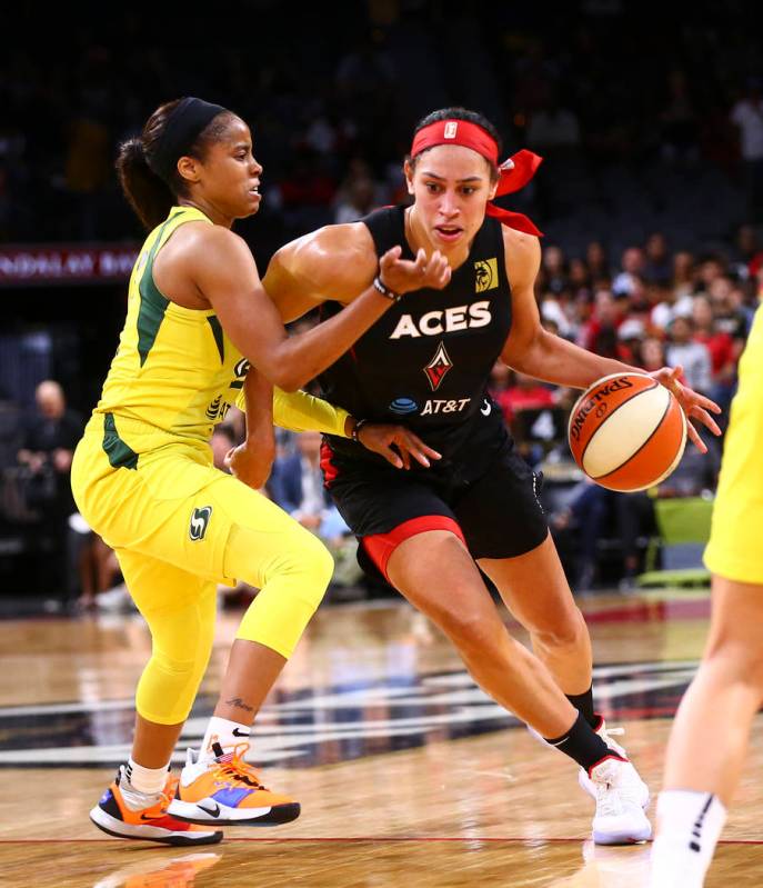 Dearica Hamby (5) de Las Vegas Aces conduce hacia la canasta pasando a Jordin Canada de Seattle ...