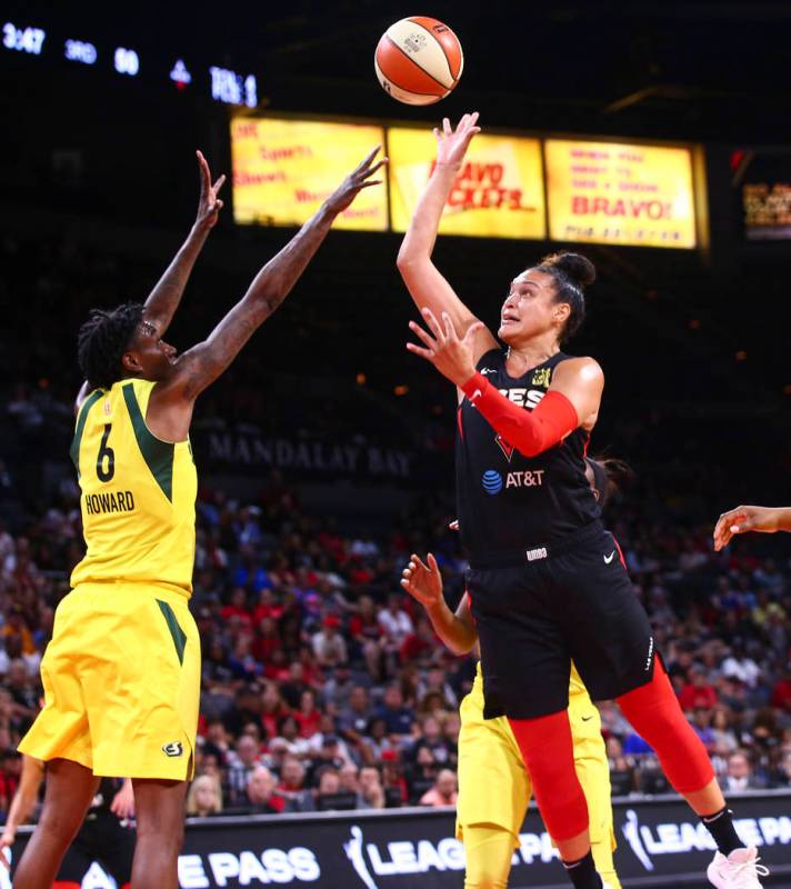 Kayla McBride de Las Vegas Aces dispara sobre Natasha Howard (6) de las Seattle Storm durante l ...