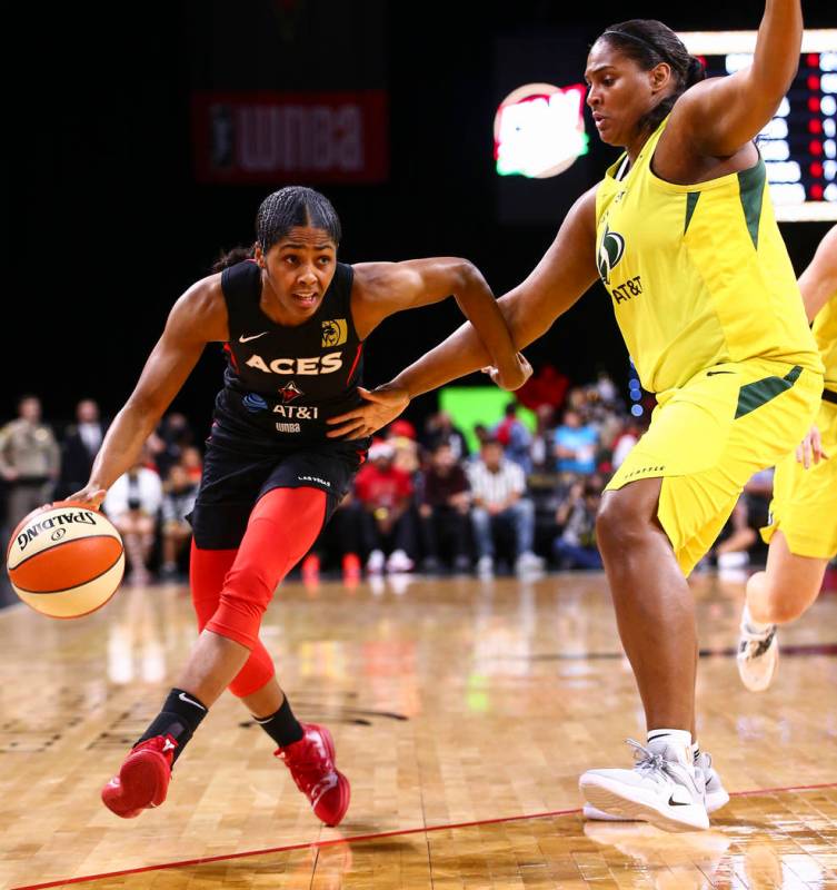 Sydney Colson de Las Vegas Aces, a la izquierda, conduce hacia la canasta contra el Courtney Pa ...