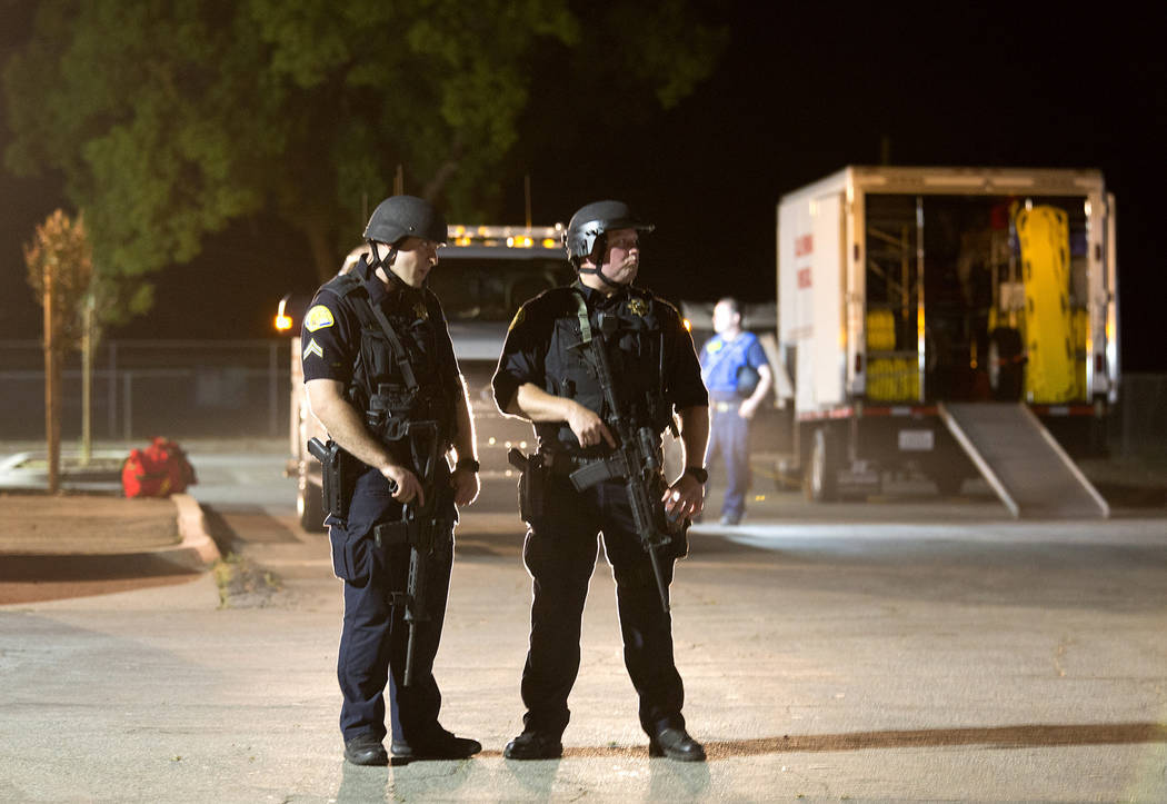 Oficiales de policía vestidos con equipo SWAT hacen guardia en el centro de primeros auxilios ...