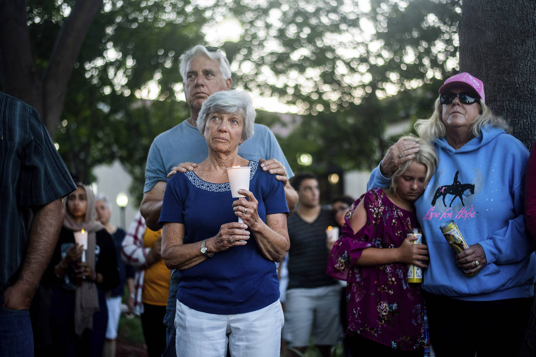 Susan Meyers y su esposo Michael Oshan escuchan un himno durante un velorio por las víctimas d ...