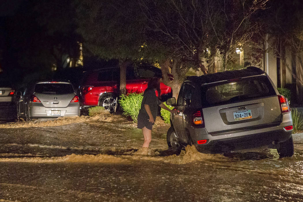 Una residente del valle suroeste, a la derecha, trata de sacar su automóvil de las inundacione ...