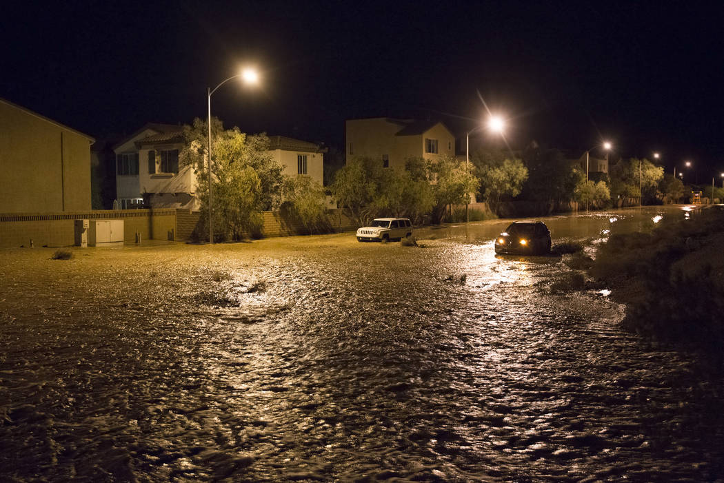 Dos vehículos están atrapados en casi tres pies de aguas de inundación cerca de la intersecc ...