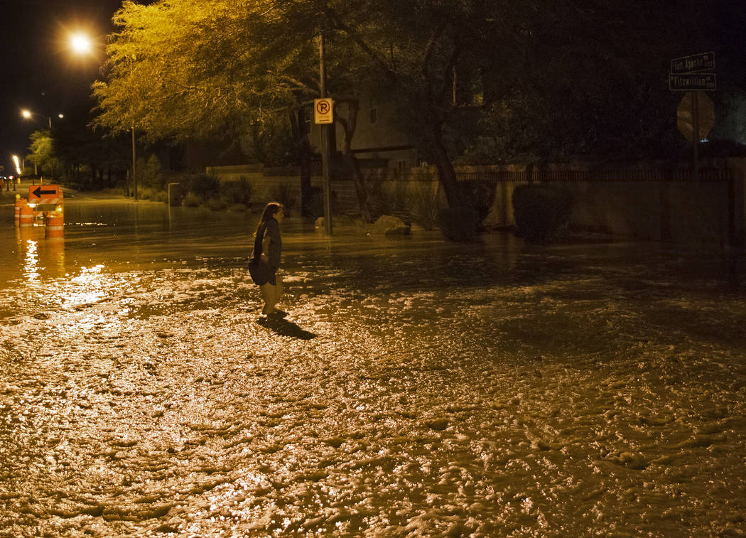 Un residente del valle suroeste intenta cruzar las aguas de la inundación cerca de tres pies d ...