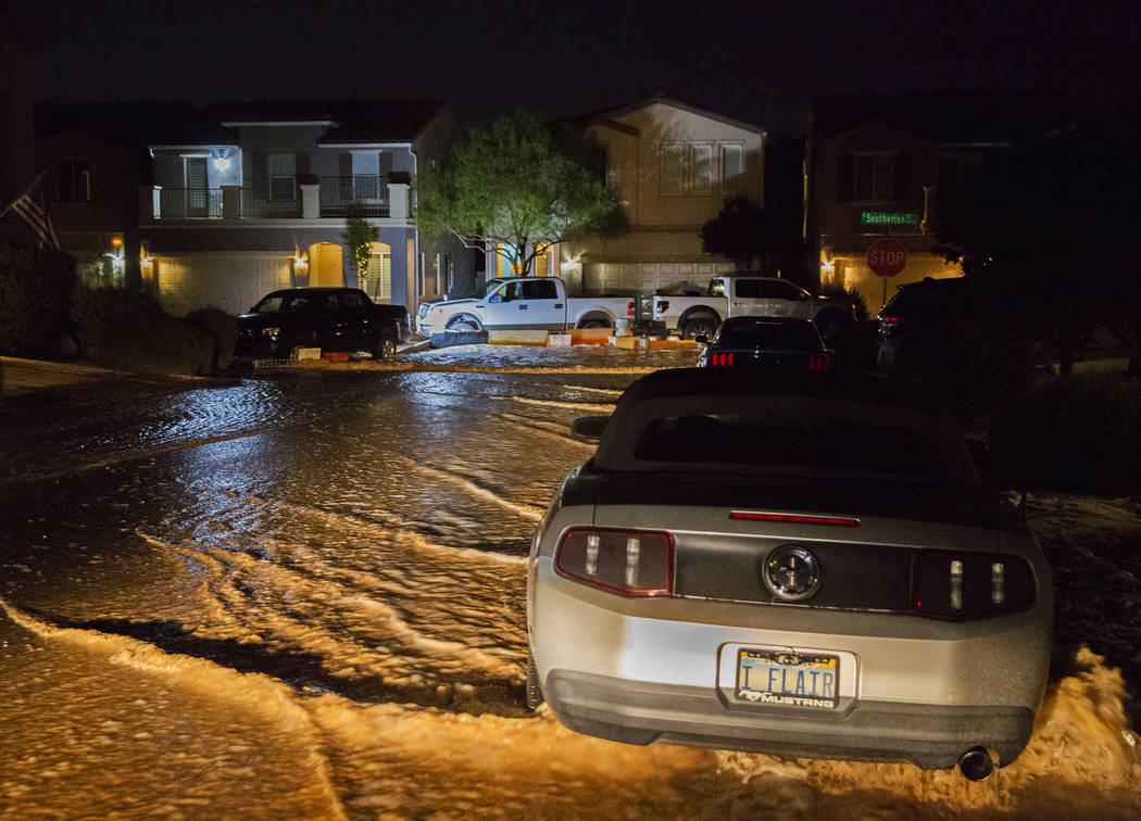 Las aguas de las inundaciones pasan por vehículos y hogares en West Fitzwilliam Avenue, cerca ...