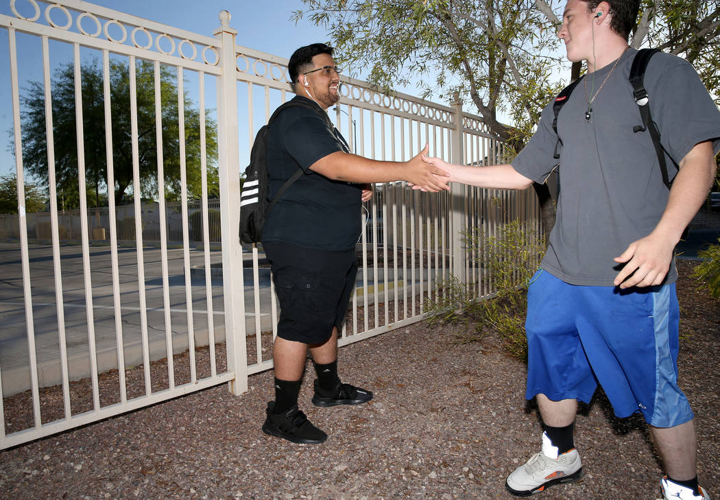 Bryan Mungia, estudiante de Sunrise Mountain High School, a la izquierda, saluda a un amigo que ...