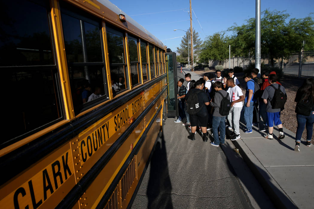 Estudiantes de la preparatoria Sunrise Mountain abordan el autobús escolar en East Owens Avenu ...