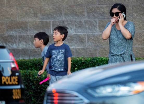 Una mujer y sus dos hijos se encuentran cerca de la escena donde un tiroteo cerca de una autopi ...