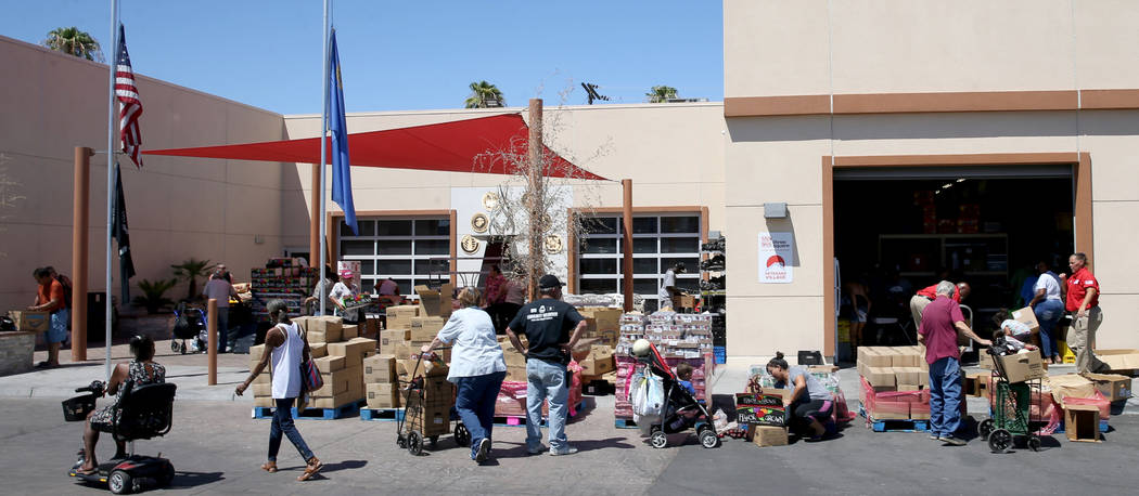 Personas recogen comida durante la distribución de un banco de alimentos en Veterans Village e ...