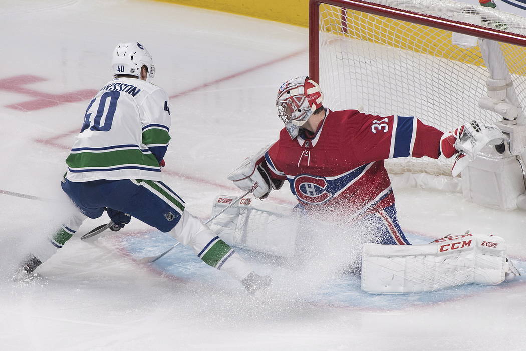 Elías Pettersson de los Vancouver Canucks se acerca al portero de los Montreal Canadiens, Care ...