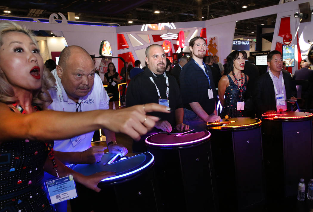 Chieko Hidaka, a la izquierda, de Gamblit Gaming, reacciona mientras asistentes a la exposició ...