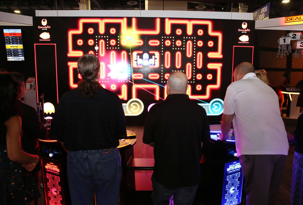 Asistentes juegan Pac-Man Battle en el stand de Gamblit Gaming durante la Global Gaming Expo en ...