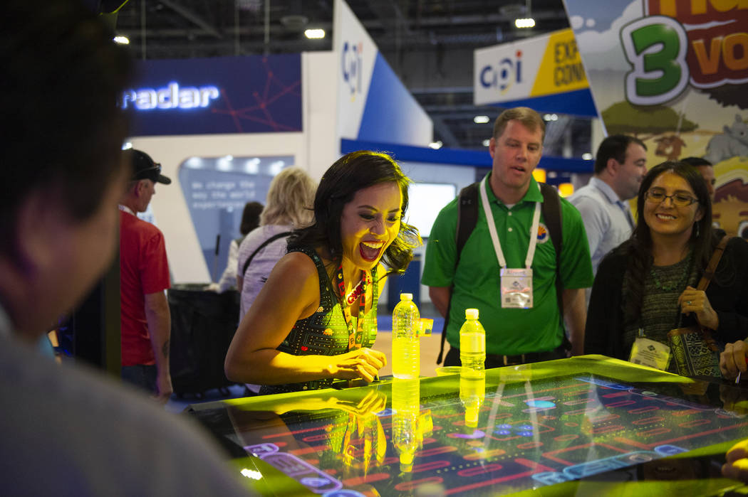 Nikki Tuazon muestra a los asistentes cómo jugar el nuevo juego Gamblit Pac-Man en la 18a Glob ...