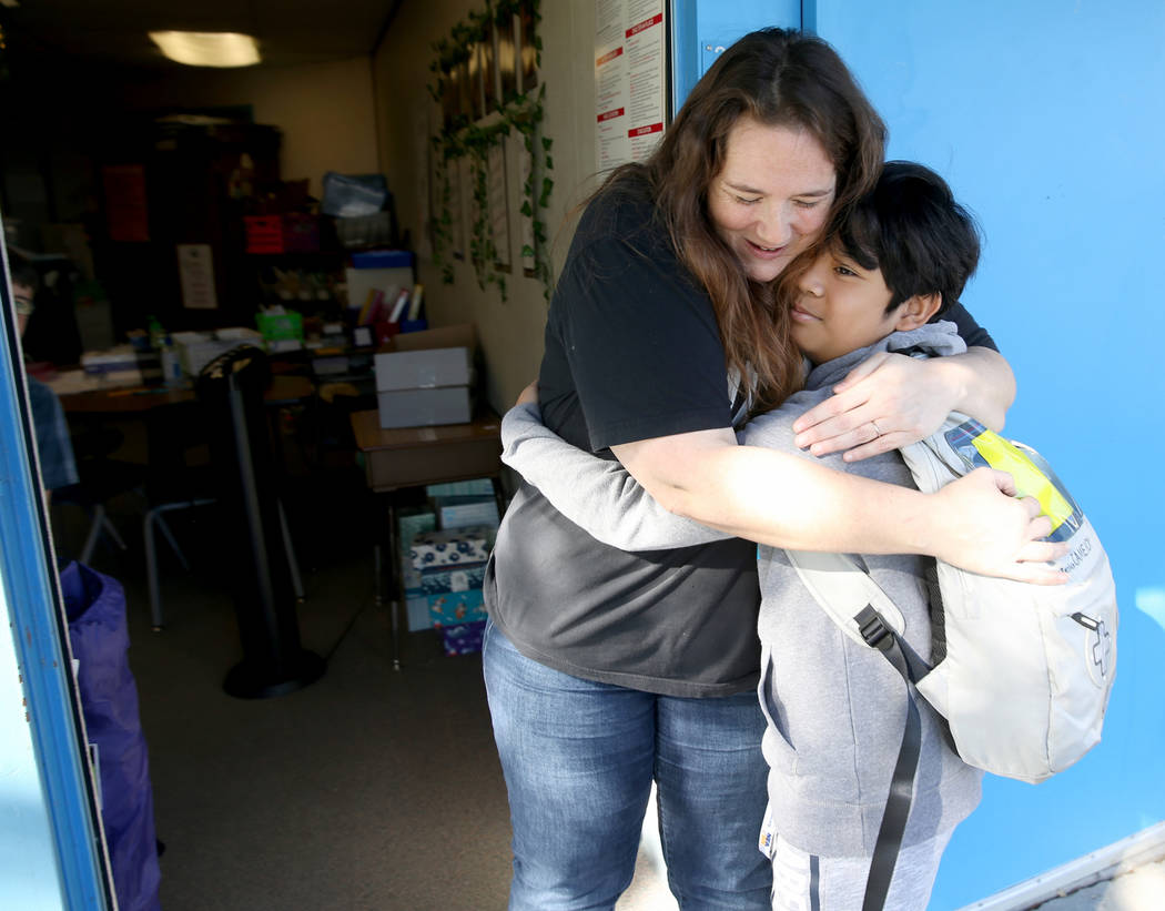 La maestra de cuarto grado de la Escuela Primaria Helen Smith, Sarah Sunnasy, recibe un abrazo ...