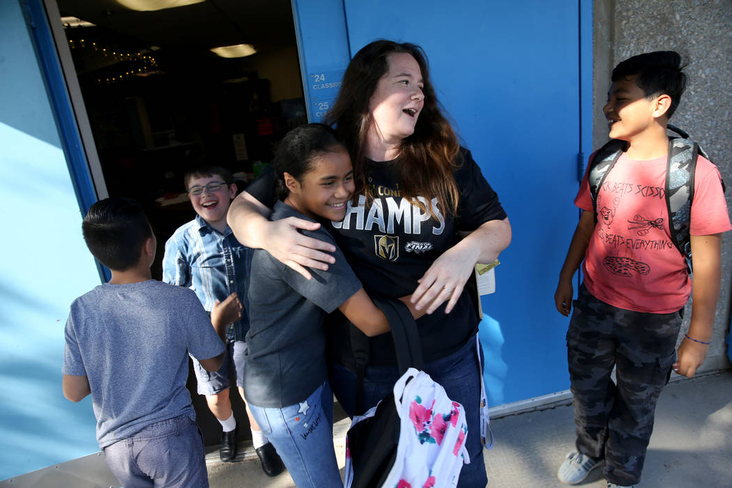 La maestra de cuarto grado de la Escuela Primaria Helen Smith, Sarah Sunnasy, recibe un abrazo ...