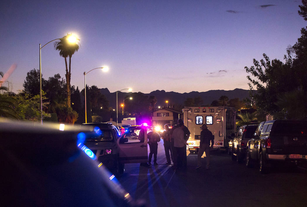 La policía de Las Vegas asegura el área alrededor de una calle residencial mientras esperan u ...