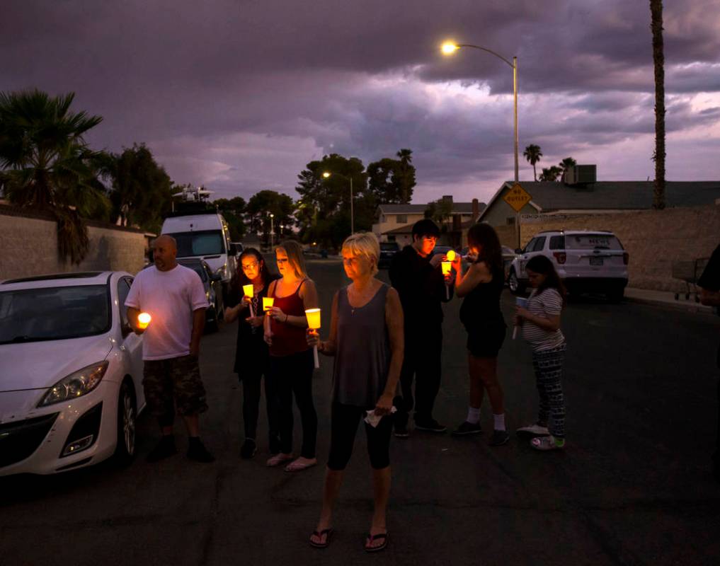 Personas sostienen velas durante un velorio en memoria de Jennifer Ratay afuera de la casa dond ...