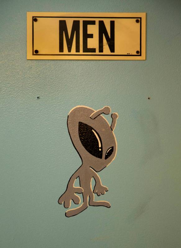 Una calcomanía de alien en la puerta del baño de hombres en el restaurante de Little A'Le'Inn ...