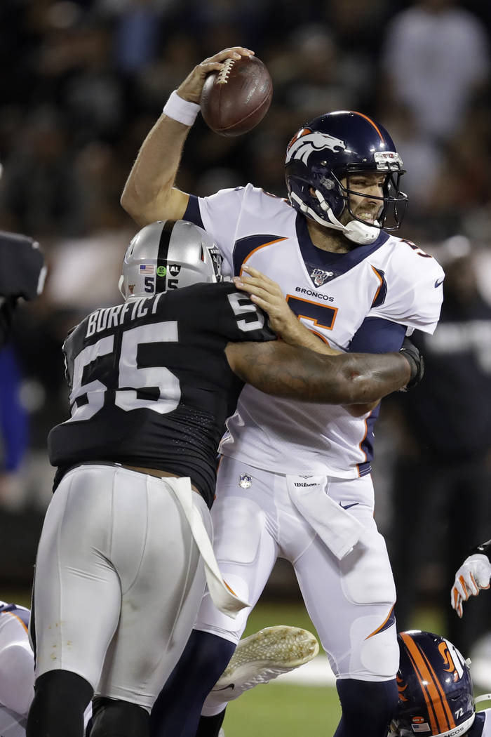 El mariscal de campo de los Denver Broncos, Joe Flacco, es atacado por el linebacker de Oakland ...