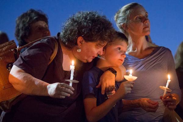 El hermano de Paula Davis, Nathan Davis, en el centro, sostiene una vela con su tía Brenda Mir ...