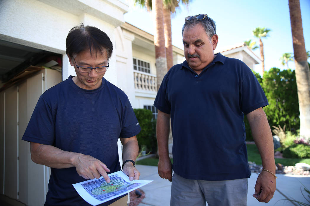 Wayne Niimi, a la izquierda, frente a la casa de su vecino Víctor Padron, muestra en un mapa l ...