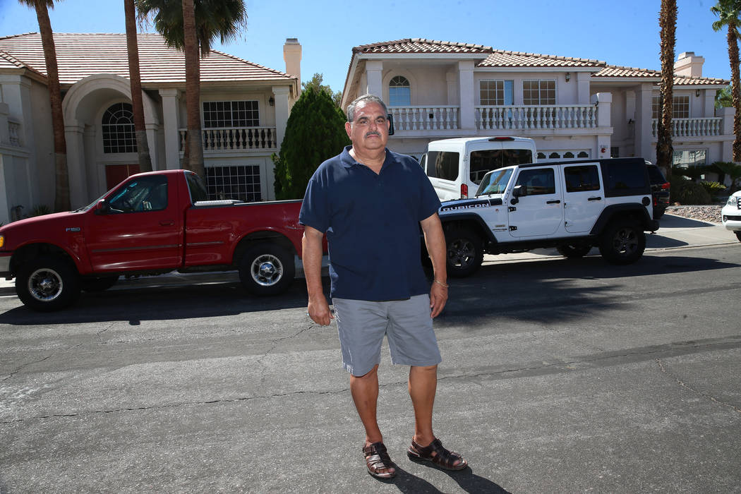 Víctor Padron posa frente a su casa, a la izquierda, en Bahama Bay Court en Las Vegas el jueve ...