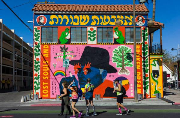 Los asistentes pasan junto a un mural durante el festival Life is Beautiful en el centro de Las ...