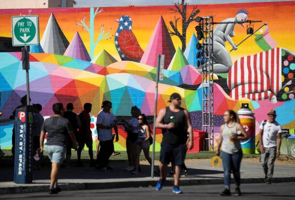 Los asistentes pasan junto a un mural durante el festival Life is Beautiful en el centro de Las ...
