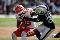 El corredor de los Kansas City Chiefs, Damien Williams, intenta escapar del safety de los Raide ...