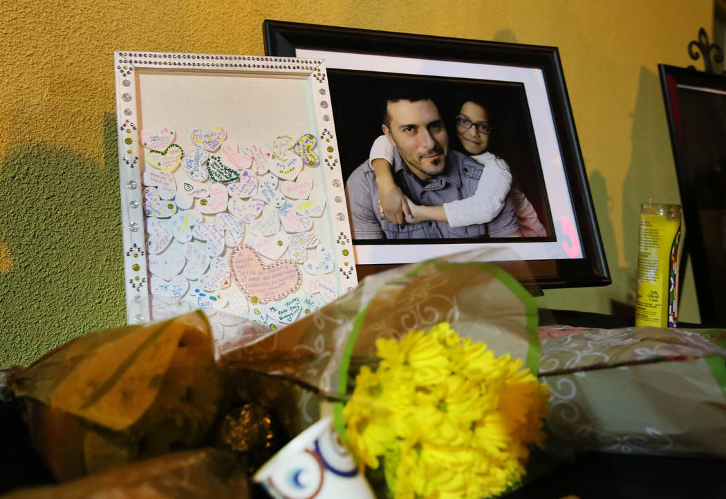 Un ramo de flores yace junto a una fotografía de Mark García y su hija Monet durante un velor ...