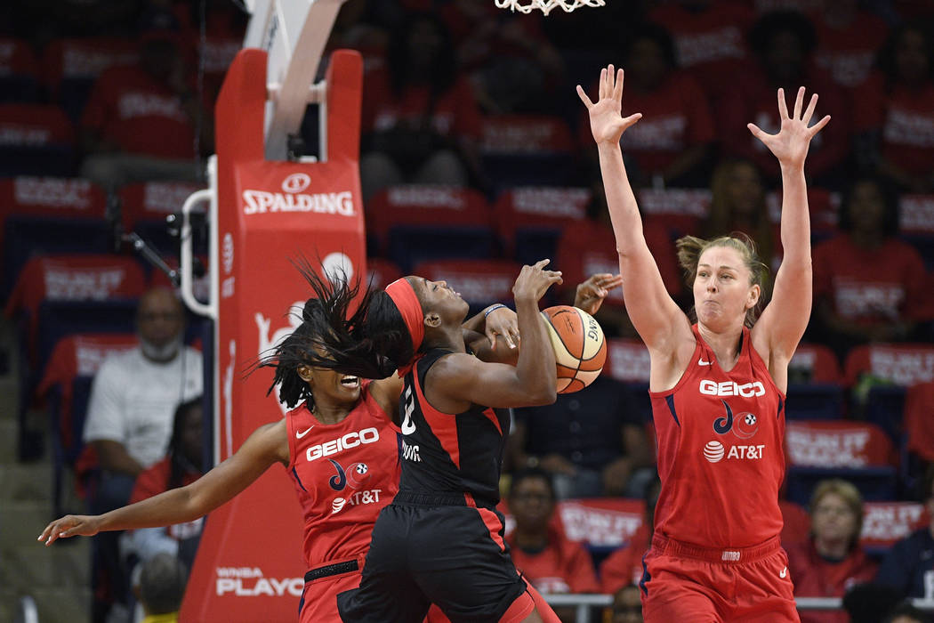 La escolta de las Washington Mystics, Ariel Atkins, atrás a la izquierda, comete una falta sob ...