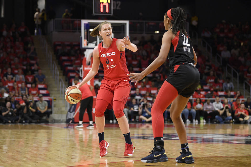 La centro de las Washington Mystics, Emma Meesseman, a la izquierda, bota el balón frente a la ...