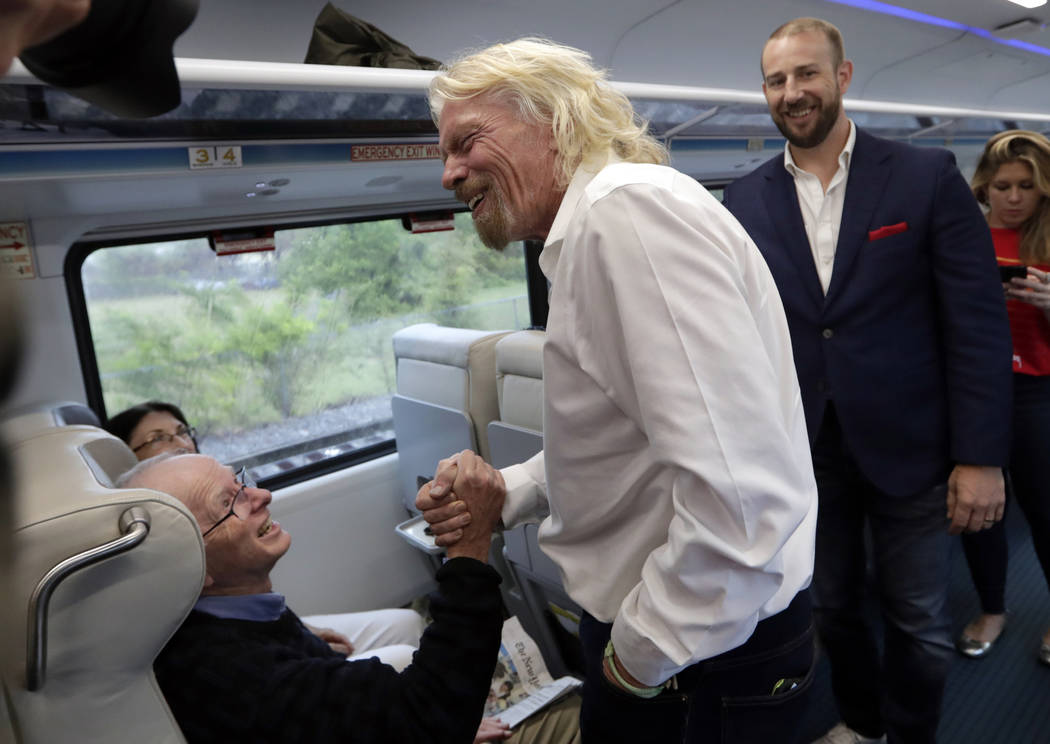 Richard Branson de Virgin Group, saluda a un pasajero mientras viaja en un tren Brightline de M ...