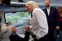 Richard Branson de Virgin Group, saluda a un pasajero mientras viaja en un tren Brightline de M ...