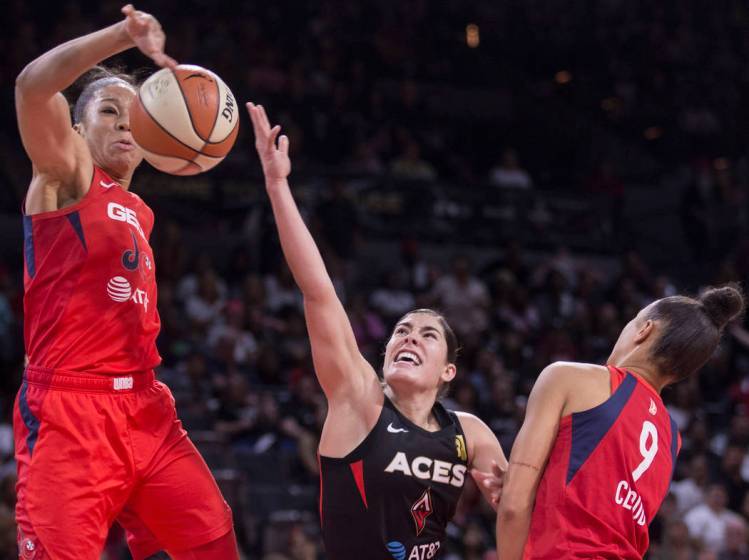 La jugadora de Las Vegas Aces, Kelsey Plum (10) intenta superar la marca de dos defensas de Was ...